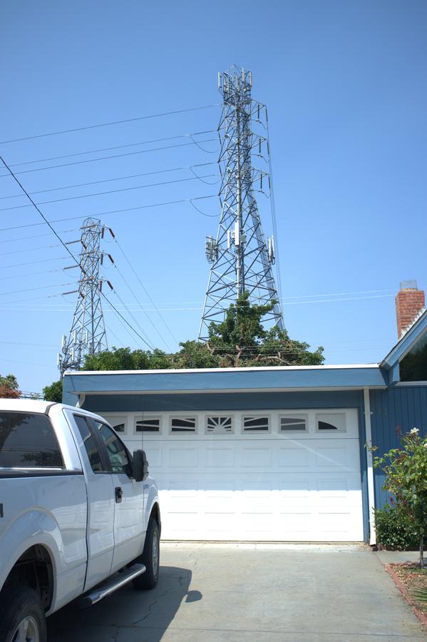 Large tower with cables behind a suburban home