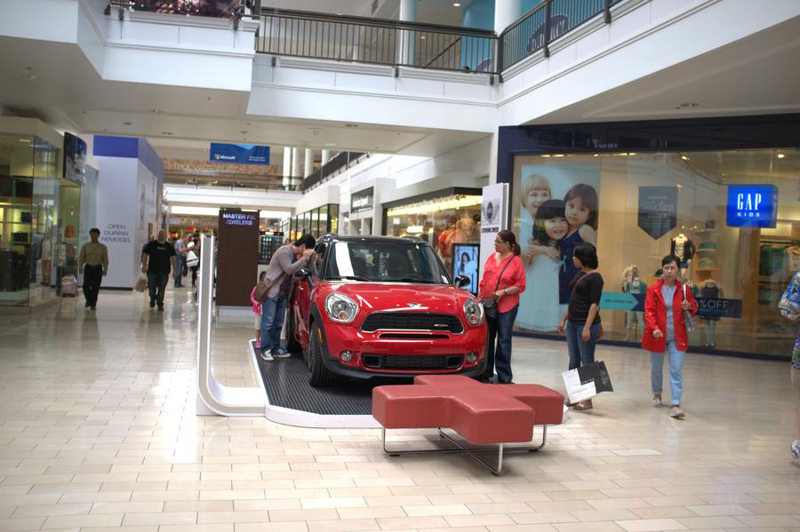 People looking at a car will be given away at the mall