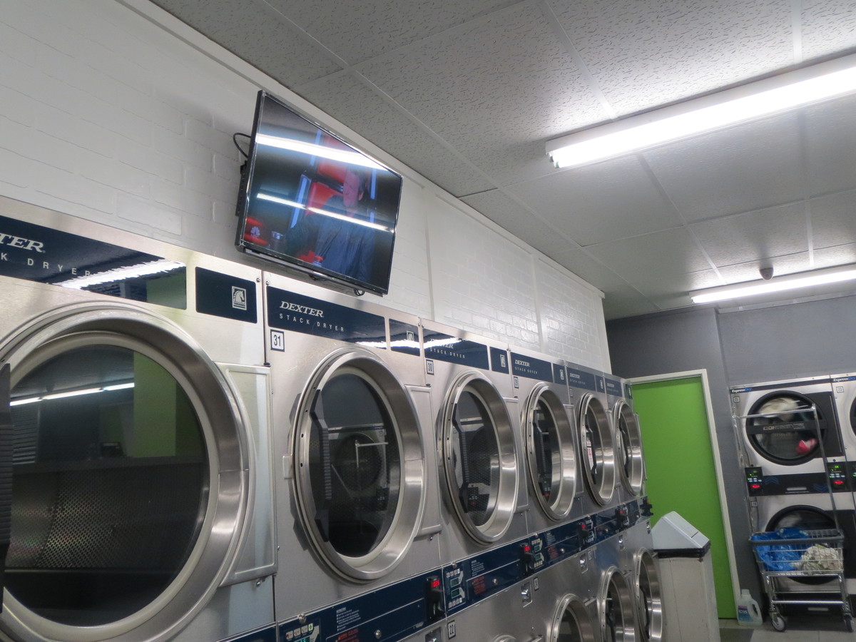 T.V. at laundromat with glare from the overhead lights