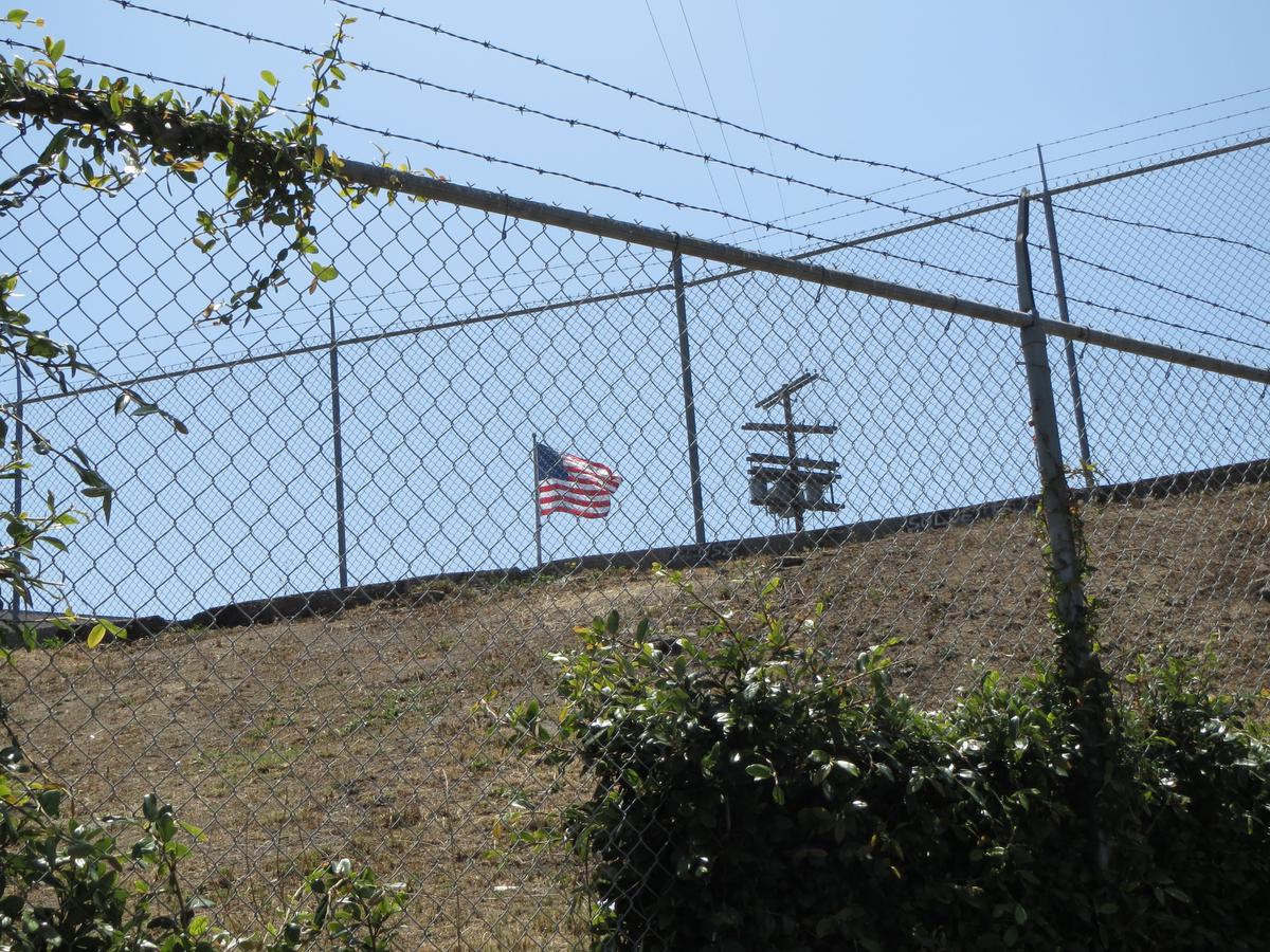 American flag behind fence with barbed wire